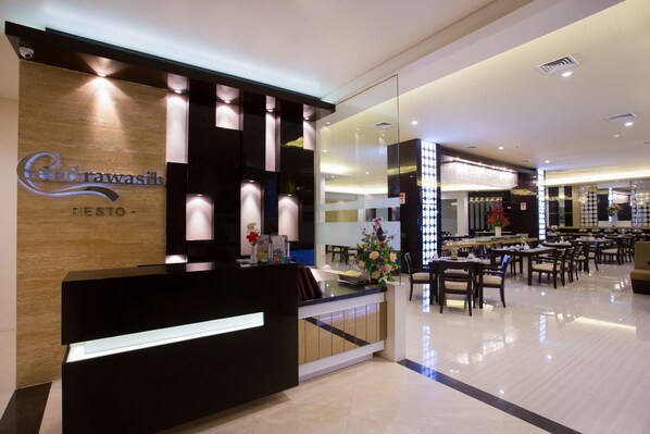 Uma área de recepção de hotel com design moderno, com balcão de atendimento, espaço para sentar e área de refeições.