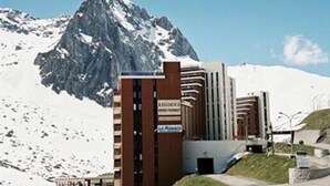 A hotel with a modern design, featuring a prominent entrance and a mountain backdrop. - Hôtel La Mandia (Bagnères-de-Bigorre)