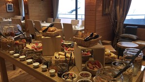 A buffet setup with various food items and condiments. - Hôtel La Mandia (Bagnères-de-Bigorre)
