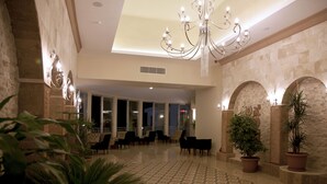A spacious lobby with a high ceiling, a chandelier, and potted plants. - Merve Sun Hotel & Spa - All Inclusive (Manavgat)