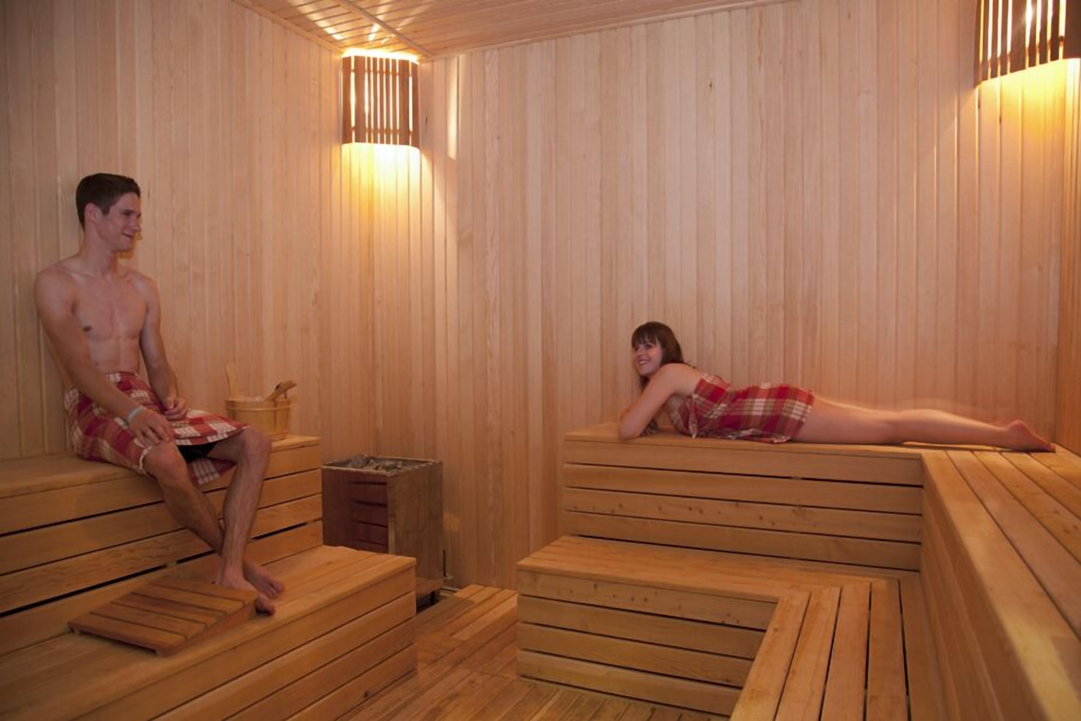 A wooden sauna with benches and a small table.