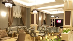 A hotel lobby with multiple seating areas, including sofas and chairs, a television, and decorative plants. - Merve Sun Hotel & Spa - All Inclusive (Manavgat)