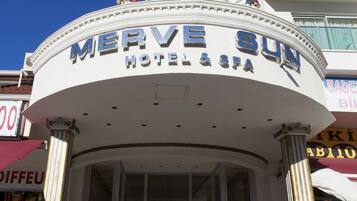 Exterior del Merve Sun Hotel & Spa con una entrada despejada, una bandera y una decoración con estrella en la parte superior.