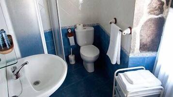 Casa de banho com lavatório, sanita e suporte para toalhas.
