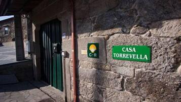 Un bâtiment en pierre avec une porte verte et une enseigne sur laquelle on peut lire « CASA TORREVELLA ».