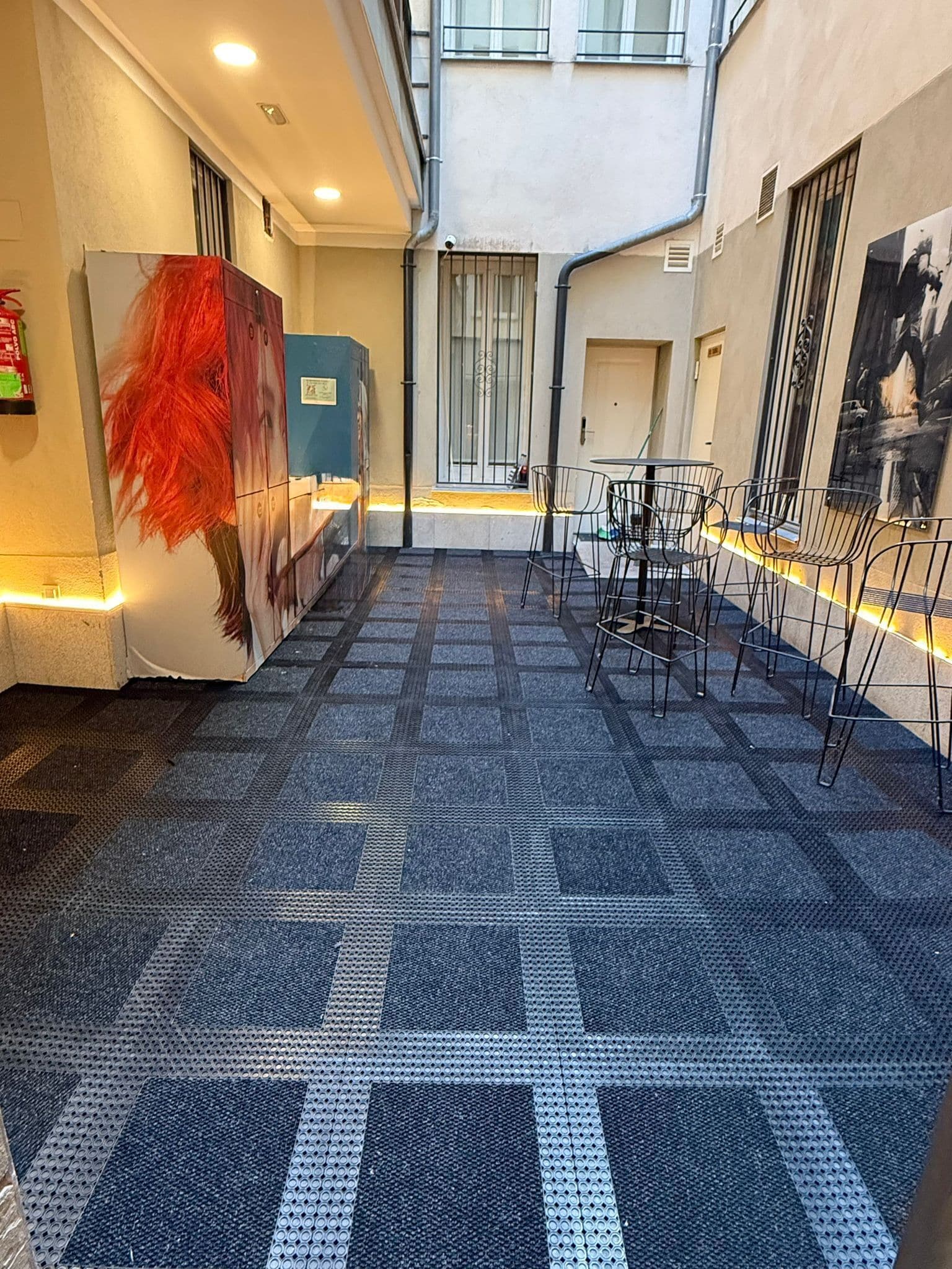 Een hotellobby met een receptiebalie, zithoek en kunstwerken aan de wanden.