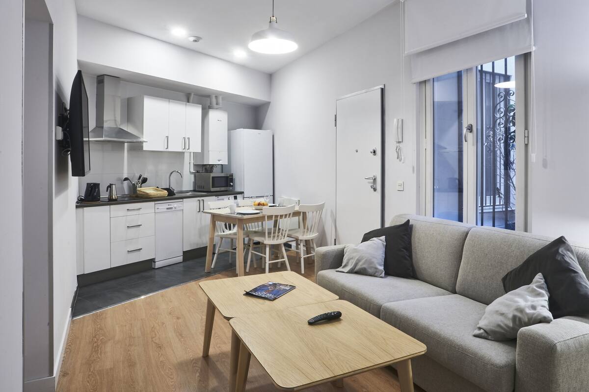 A modern apartment with a kitchen, dining area, and living room.