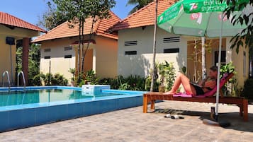 Utomhuspool, parasoller och solstolar