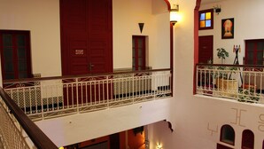 A multi-level hotel interior with a balcony, ornate railings, and a staircase. - Riad Meftaha (Rabat)