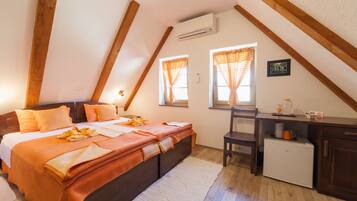 Un dormitorio con cama, escritorio y un refrigerador pequeño.
