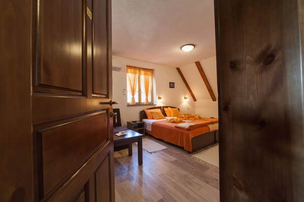 A room with a bed, bedside table, and a window with curtains.