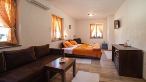 A compact room with a bed, a sofa, a small table, and a kitchenette. - House Rustico (Plitvicka Jezera)