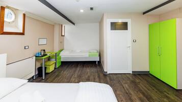 Una habitación de hotel con una cama, un escritorio, una silla, un armario y una ventana.