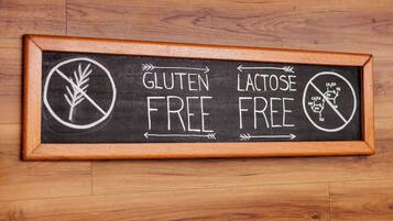 Een bord met een lijst waarop 'GLUTEN FREE' en 'LACTOSE FREE' staat geschreven.