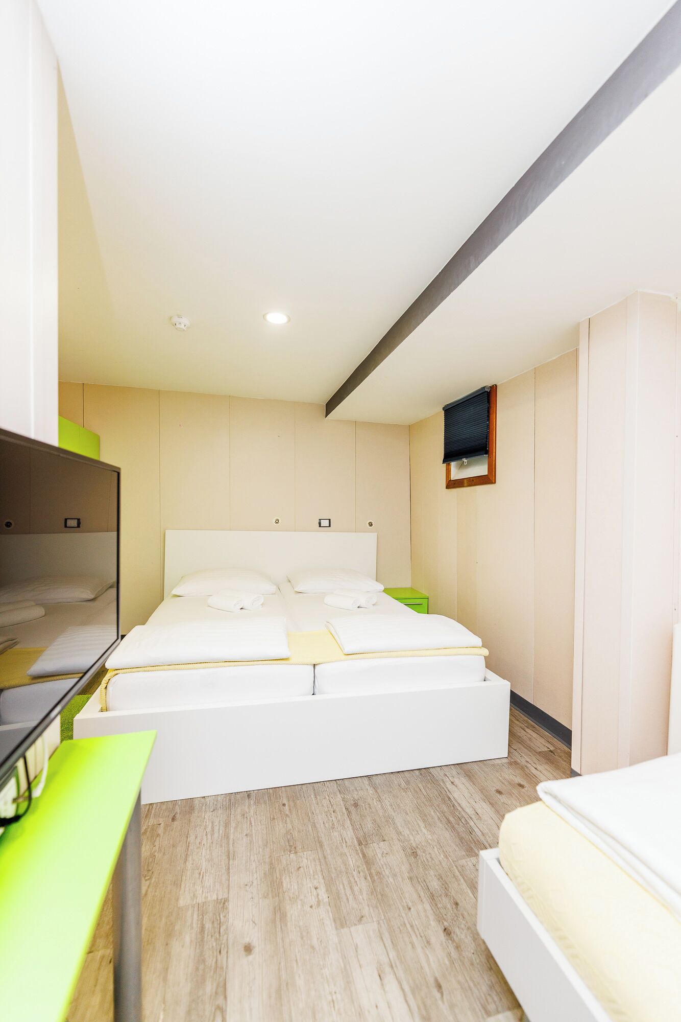 Moderni hotellihuone, jossa on suuri sänky, työpöytä ja vaatekaappi.