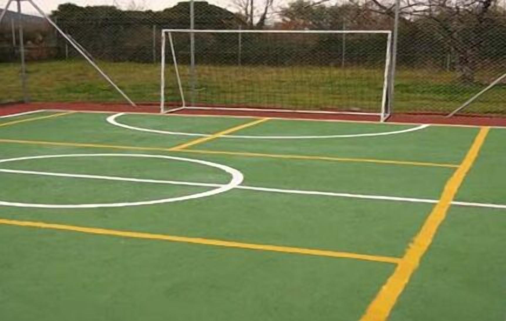 Una cancha deportiva al aire libre con un arco y una valla.