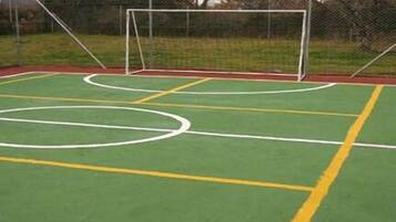 Una cancha deportiva al aire libre con un arco y una valla.