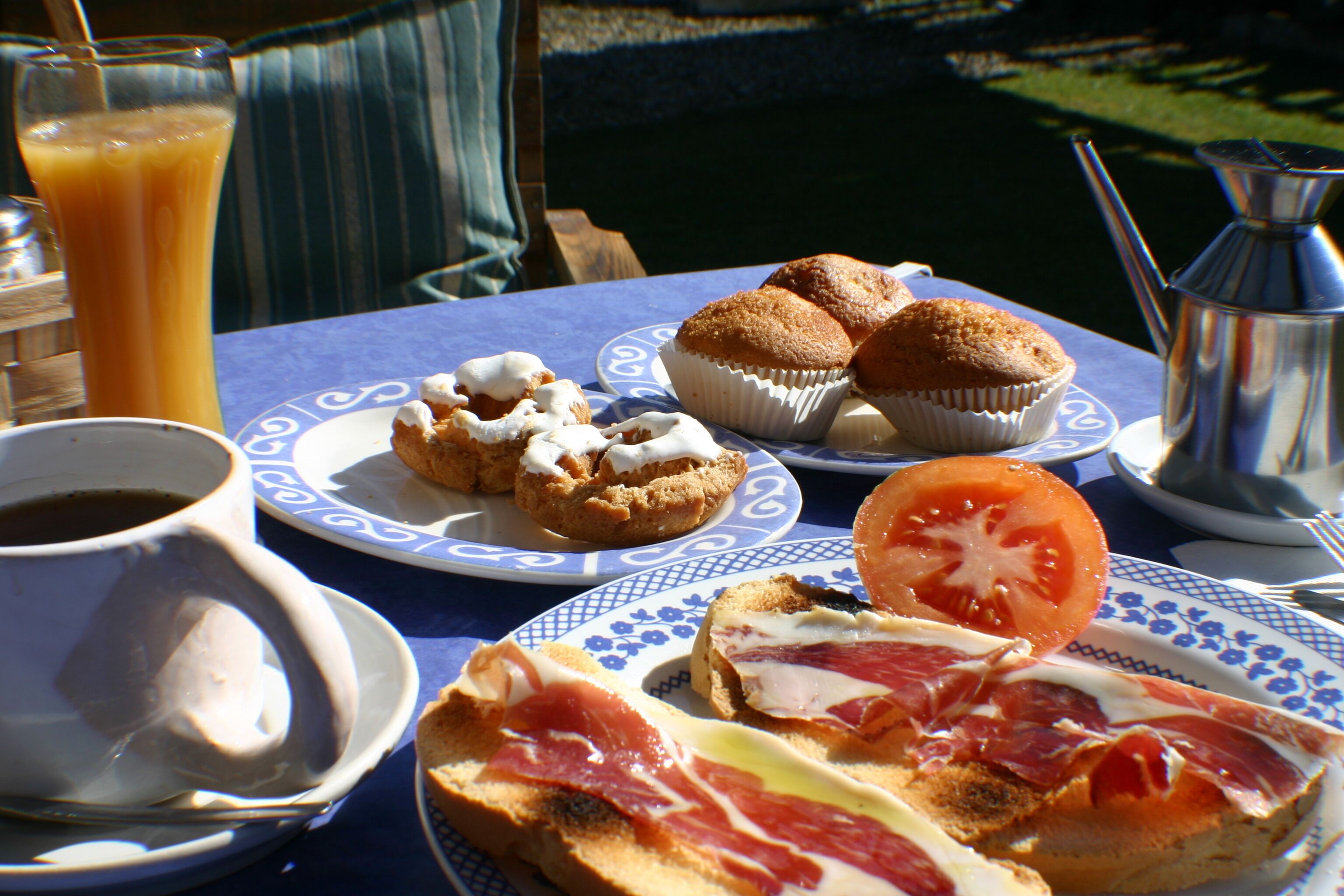 Een tafel met een bord eten, een glas sinaasappelsap en een kop koffie.
