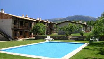 Relax by the pool surrounded by lush gardens and distant mountain views.