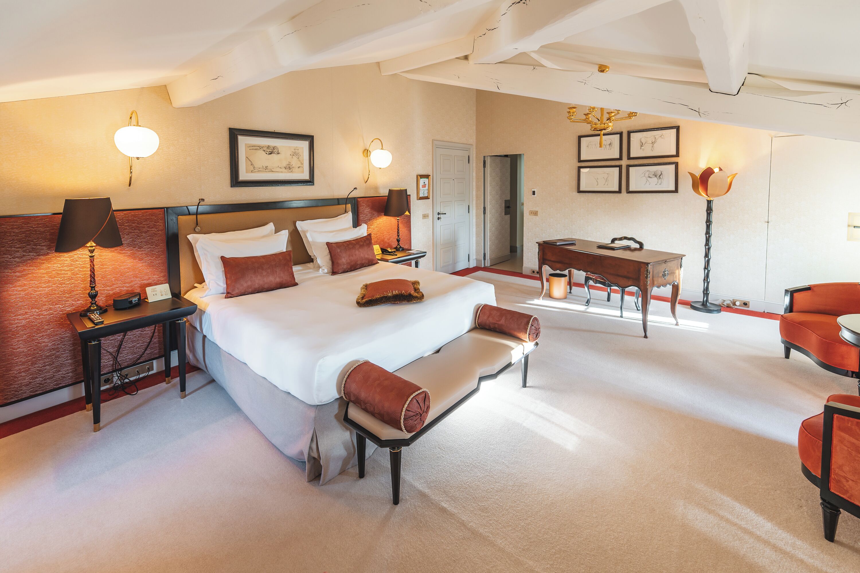 A hotel room with a large bed, bedside tables, a desk, and a chair.