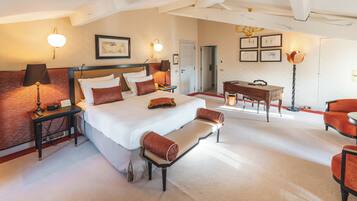 A hotel room with a large bed, bedside tables, a desk, and a chair.