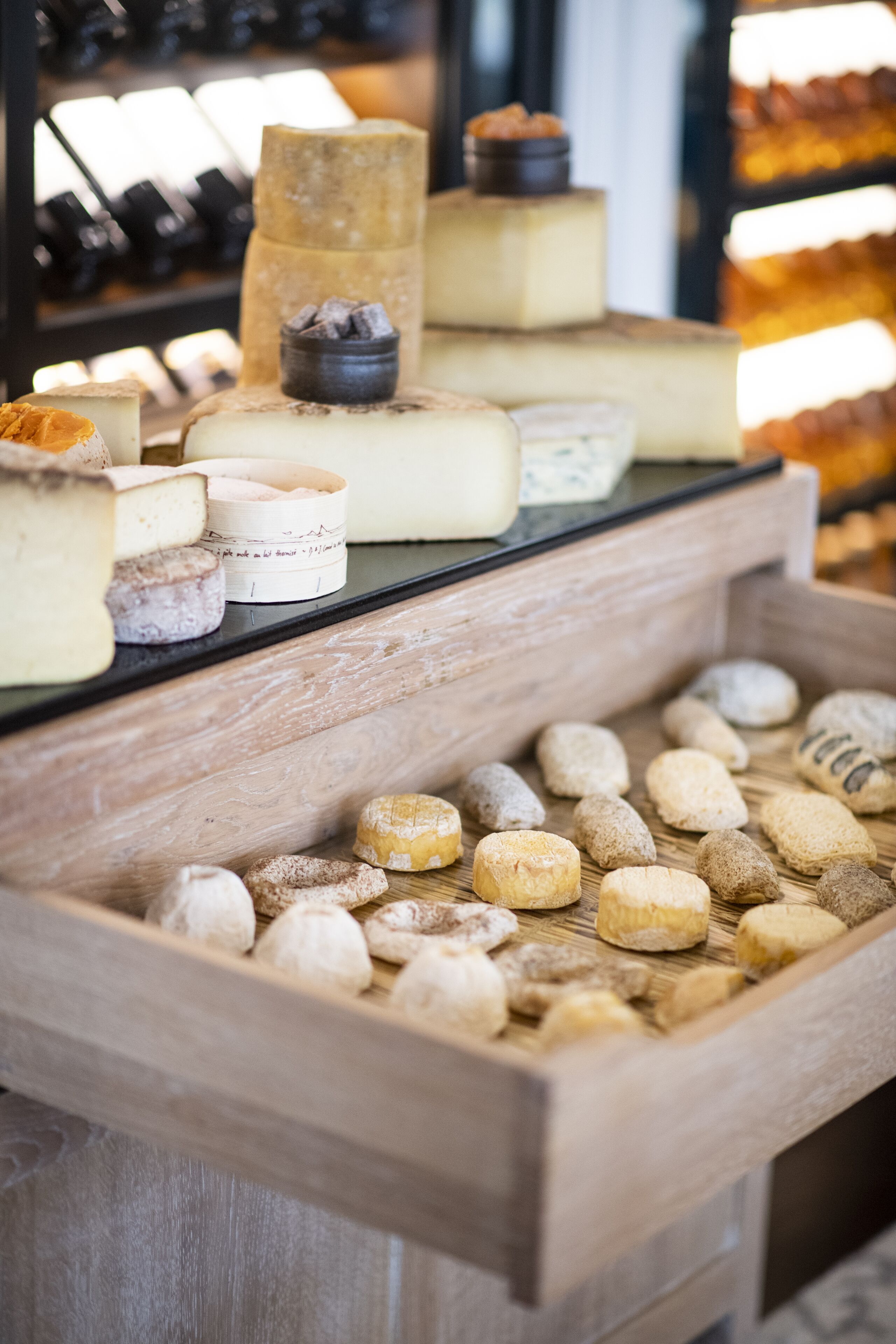 A cheese display with various types of cheese and pastries.