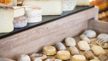 A cheese display with various types of cheese and pastries.