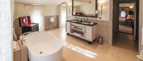 Une salle de bain moderne avec une baignoire sur pieds, un grand miroir et un meuble-lavabo doté de deux vasques.