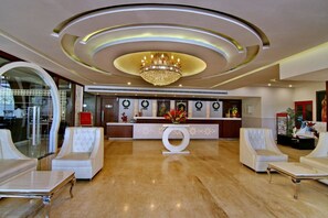A hotel lobby with a reception desk, seating area, and a chandelier. - Hotel Casaya Inn (Lucknow)