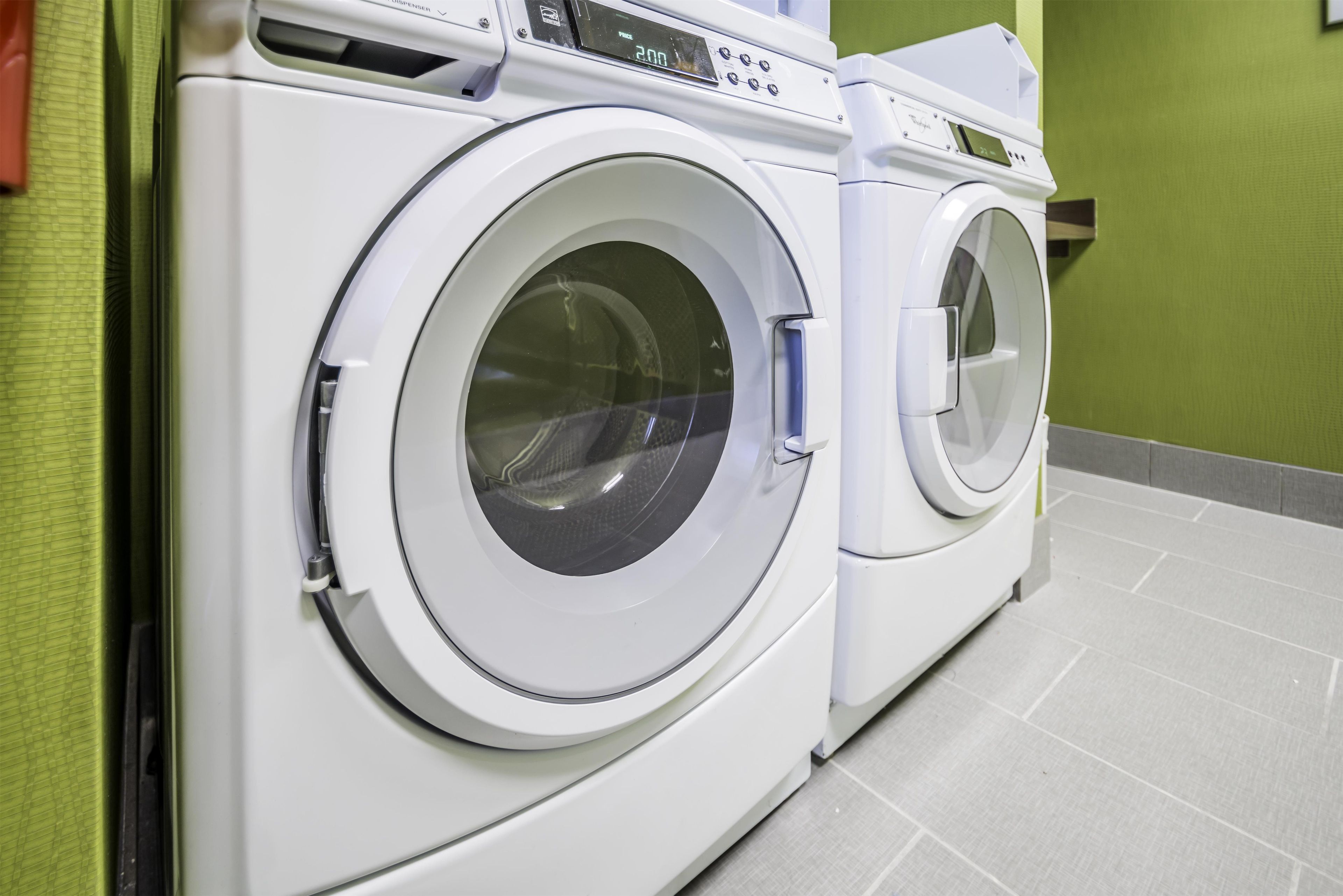 A front view of a white front-loading washing machine with a digital display and control panel.