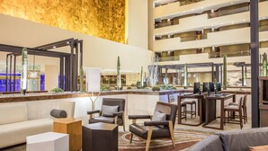 Un vestíbulo amplio con techo alto, muebles modernos y una zona de estar central.
