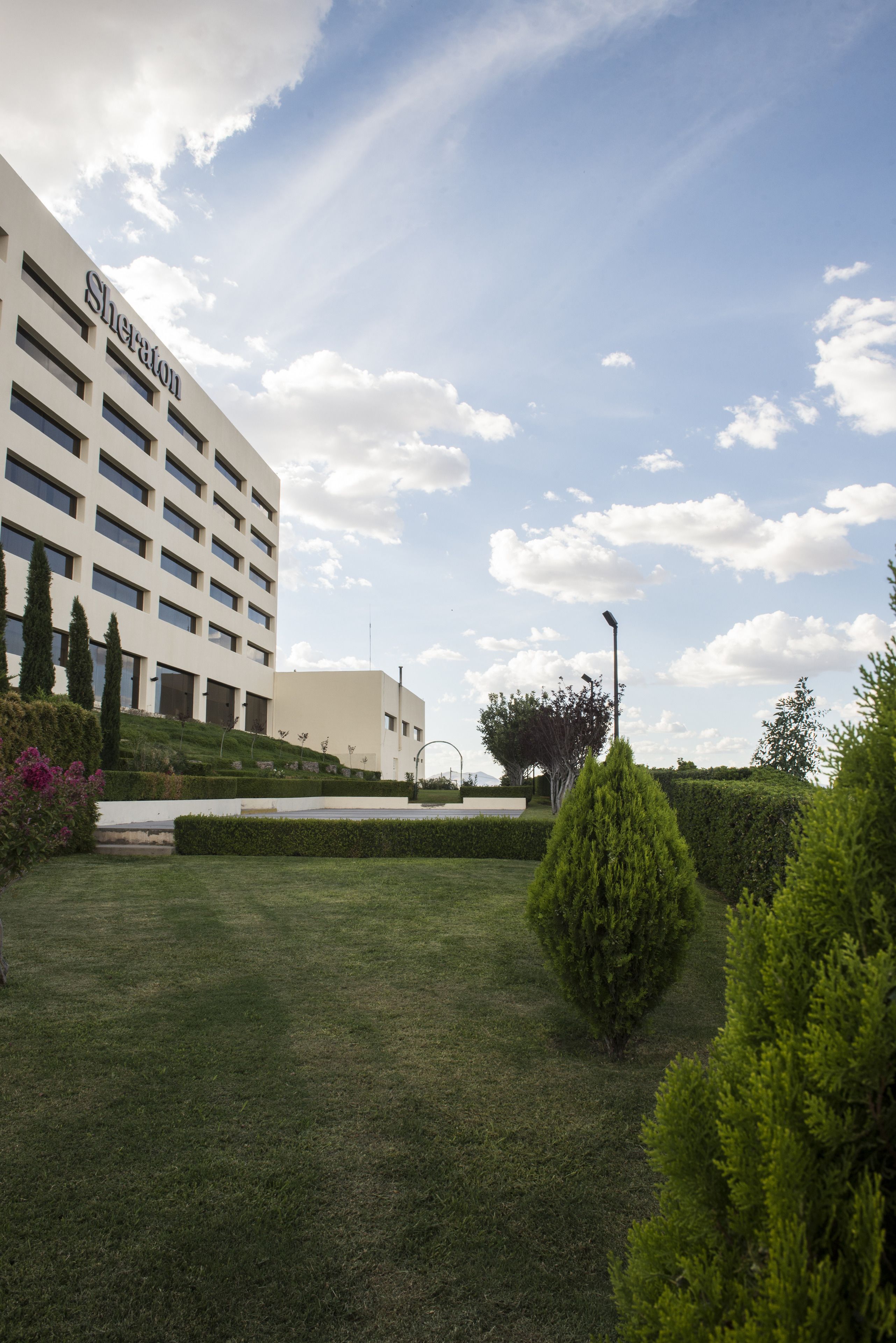 Un hotel de diseño moderno, un césped bien cuidado y un cielo despejado.