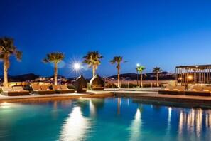 A pool area with lounge chairs and palm trees at dusk. - Sheraton Chihuahua Soberano (Chihuahua)