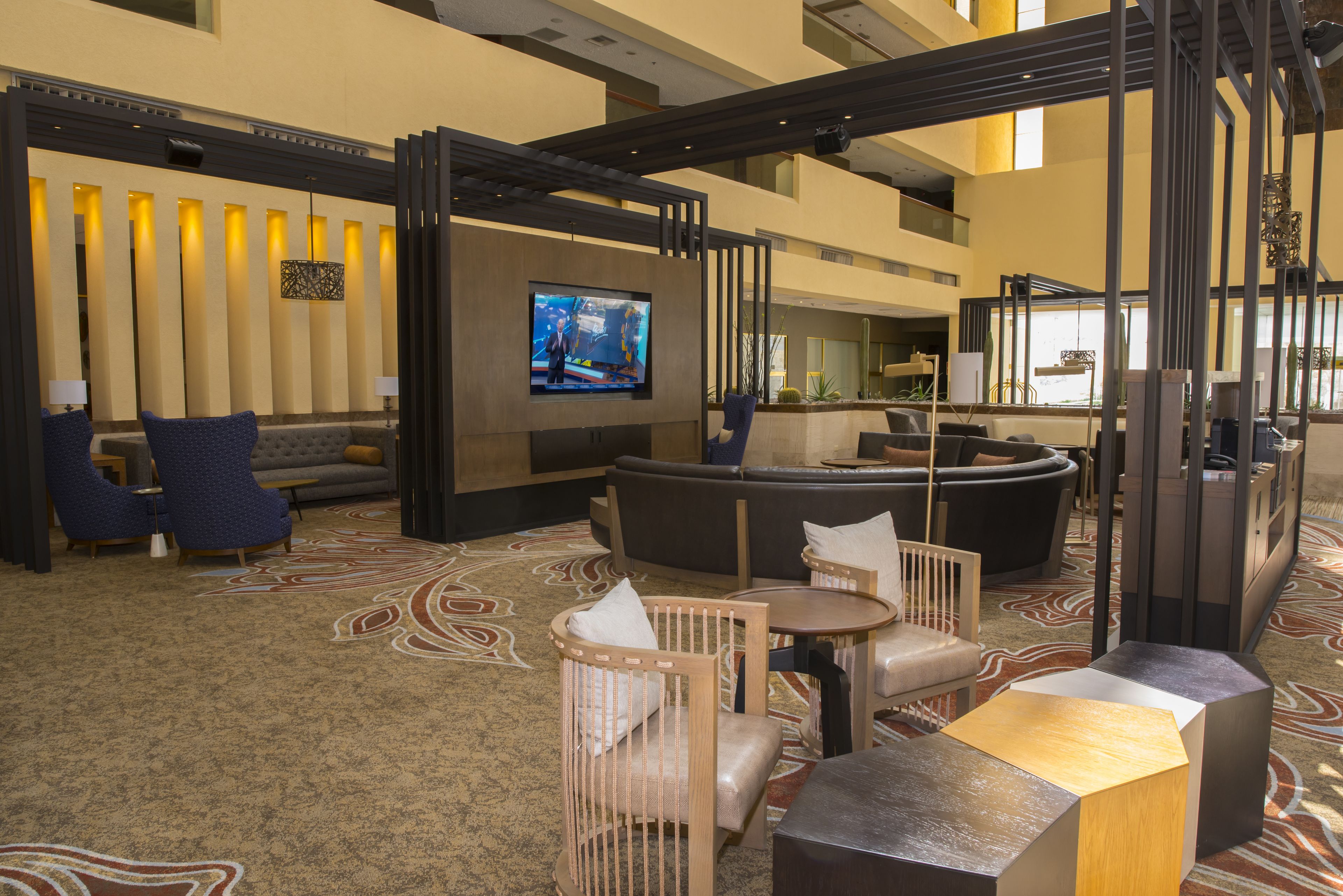 Eine Lobby mit Sitzgelegenheiten, einem Fernseher und einer Rezeption.