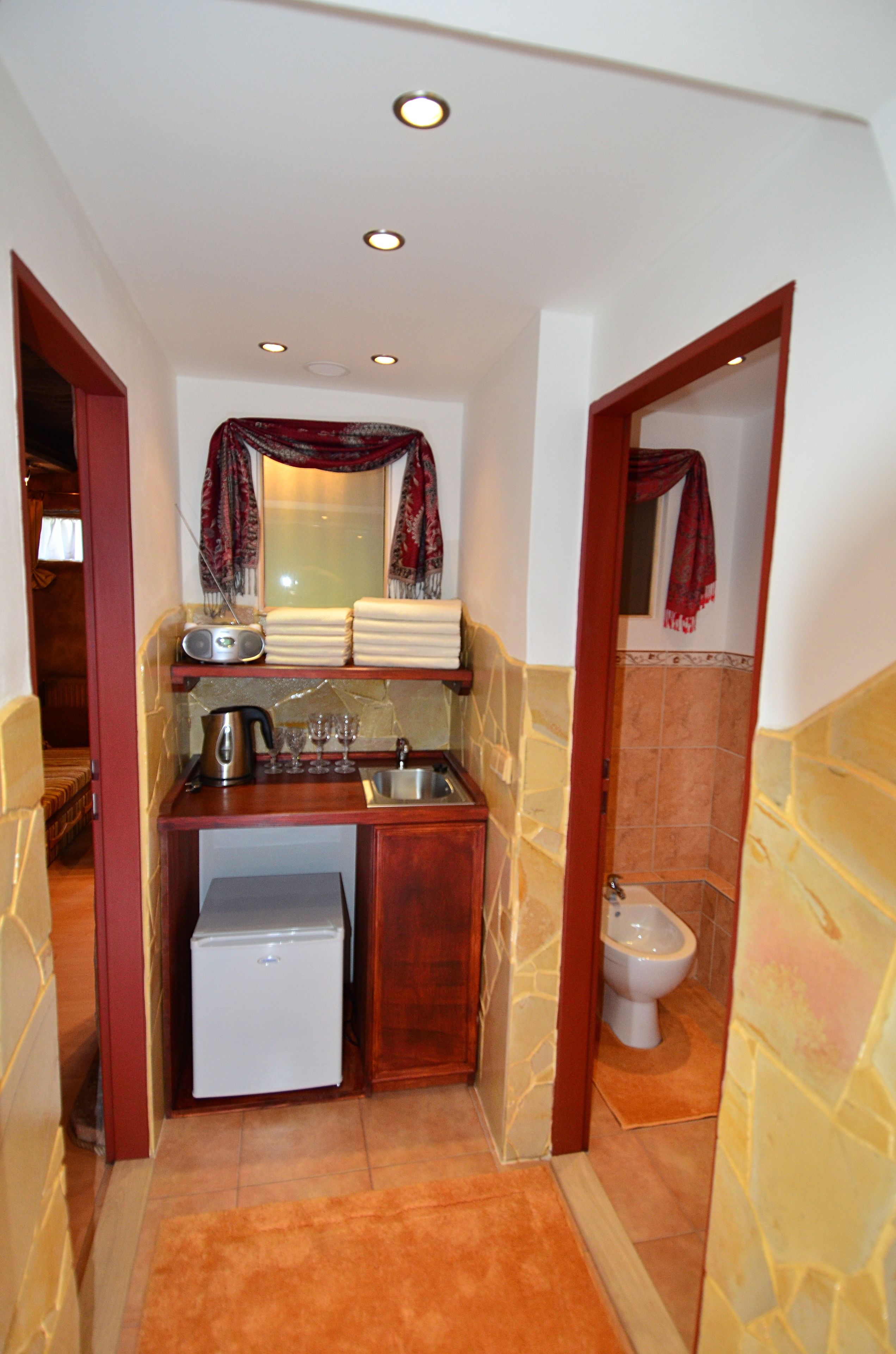 A compact kitchen with a refrigerator, sink, and a small stove.