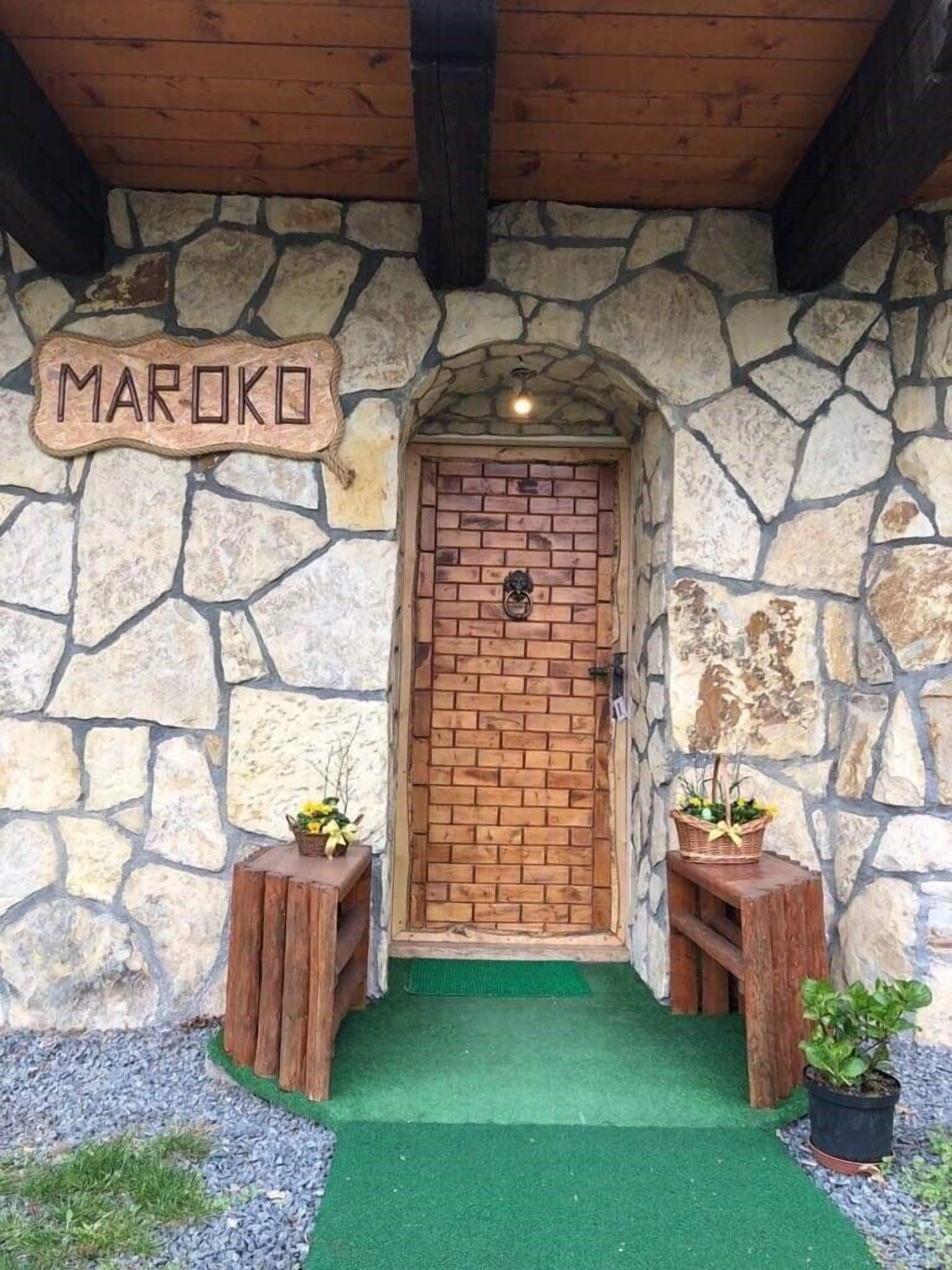 Un edificio de piedra con una puerta de madera que dice 'MAROKO'.