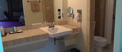 A bathroom with a sink, mirror, towel rack, and toilet.