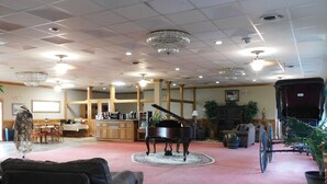 A spacious lobby with a grand piano, a dining area, and a carriage. - Cedar Glade Resort (Horseshoe Bend)