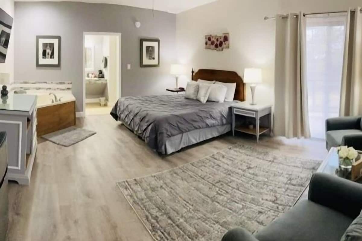 A modern bedroom with a bed, bedside tables, a desk, and a television.