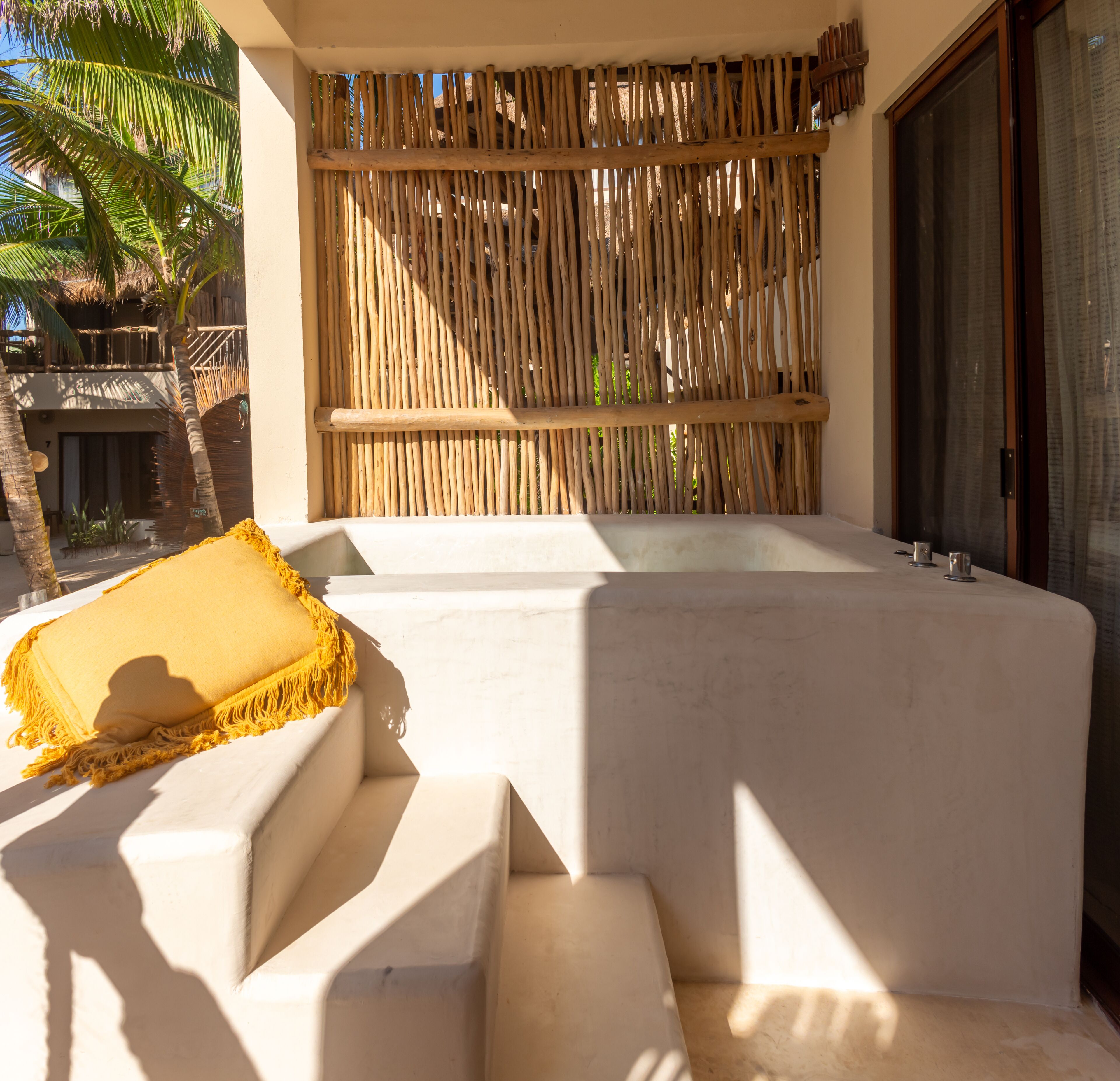 A spa area with a wooden wall, a bathtub, and a yellow towel.