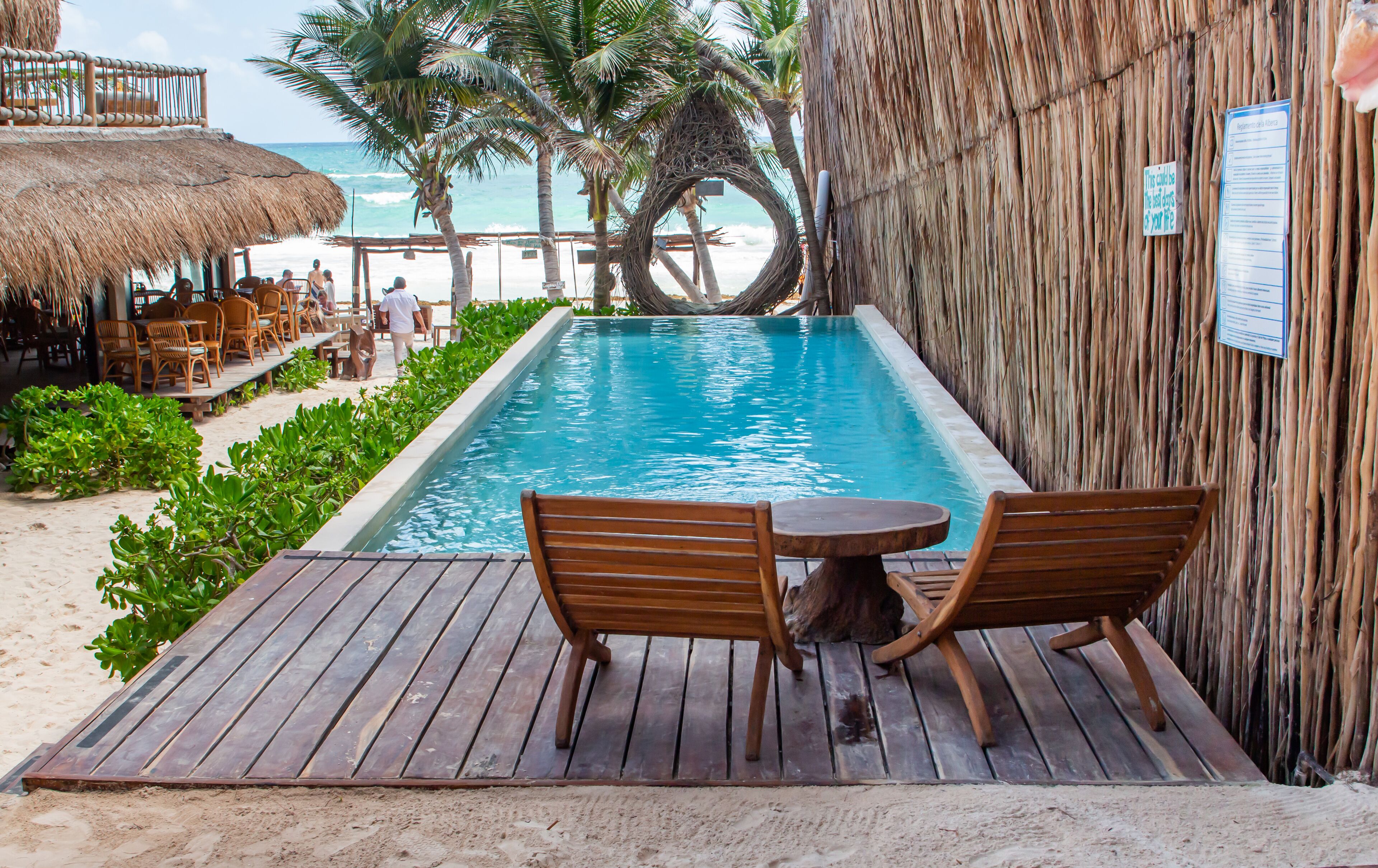 Una piscina al aire libre, sombrillas, sillones reclinables de piscina