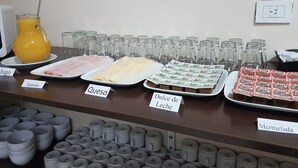 A buffet with labeled food items including ham, cheese, dulce de leche, and marmalade. - Buenos Aires Inn Hotel (Buenos Aires)