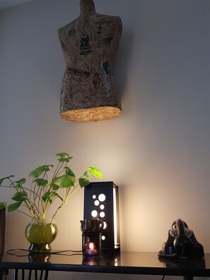 A table with a potted plant, a lit candle, and a vintage telephone. - Buenos Aires Inn Hotel (Buenos Aires)