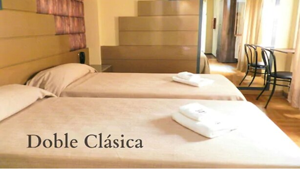 A double room with two beds, a staircase, and a chair. - Buenos Aires Inn Hotel (Buenos Aires)