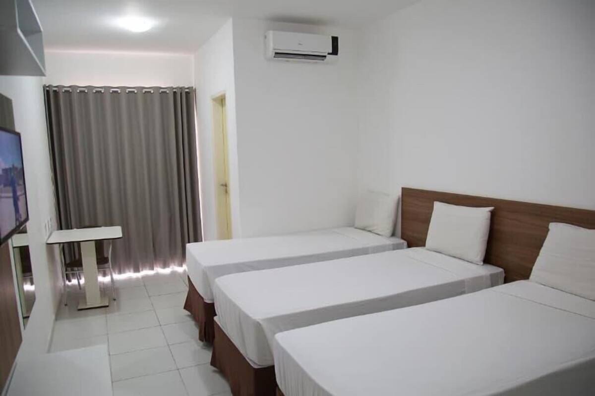 Une chambre d’hôtel avec deux lits, une télévision et un appareil de climatisation.