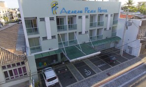 A multi-story building with a tiled facade and a sign reading "Araras Praia Hotel". - Rede Andrade Araras (Aracaju)