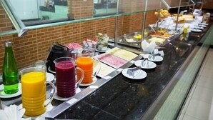 A buffet with various food items and beverages. - Rede Andrade Araras (Aracaju)