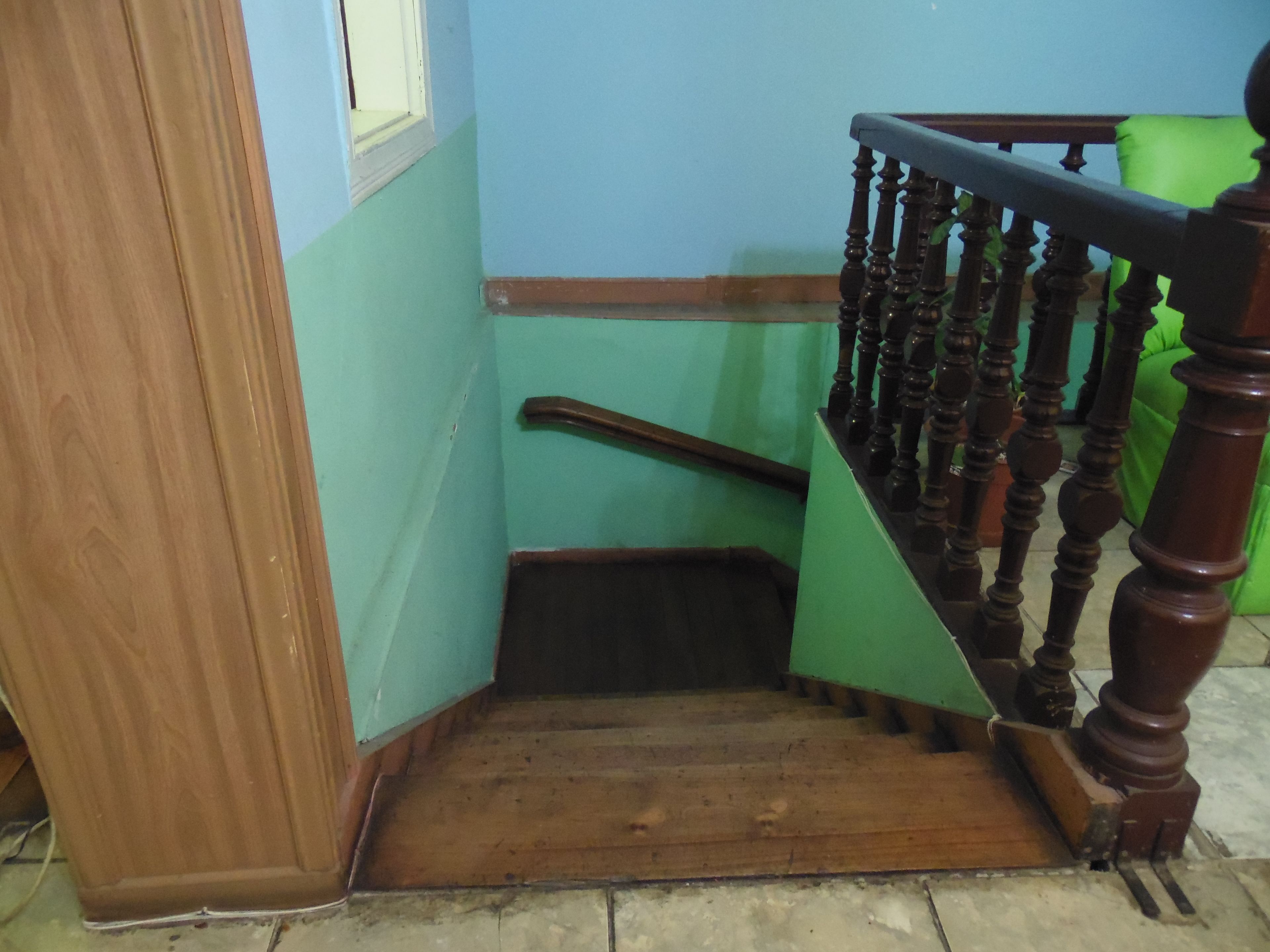 A wooden staircase with a handrail and a wooden door.