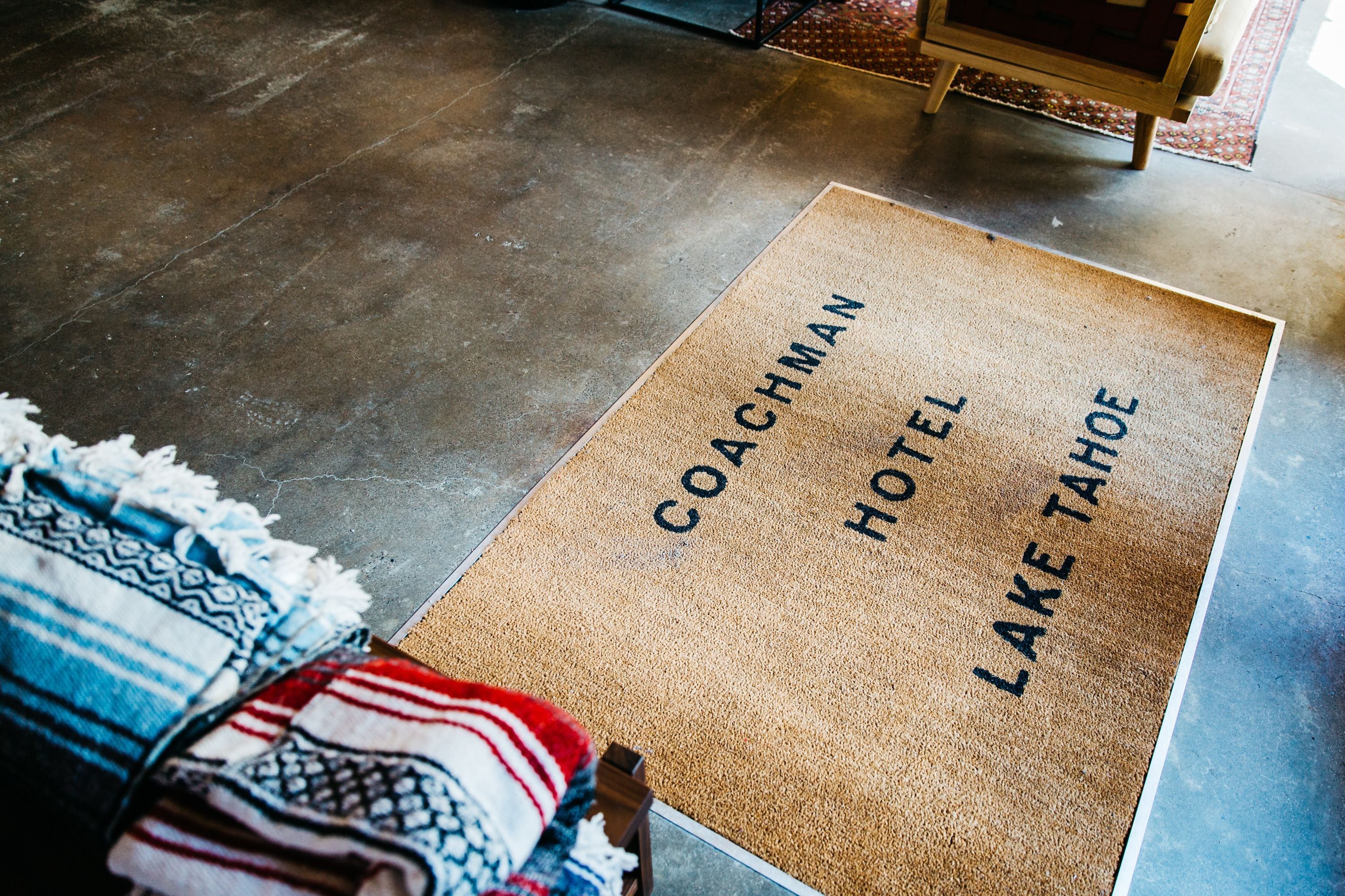 A doormat with the text "COACHMAN HOTEL LAKE TAHOE".
