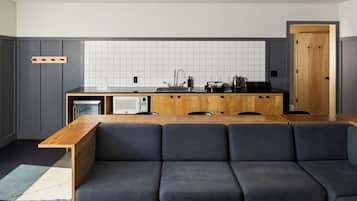 A modern kitchen with a wooden countertop, a built-in microwave, and a sink.